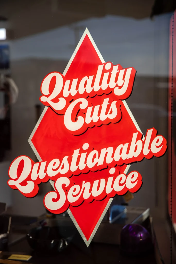 hand-painted-white-gold-leaf-signage-for-lil-rickys-barber-cuts-portrait-scaled.webp